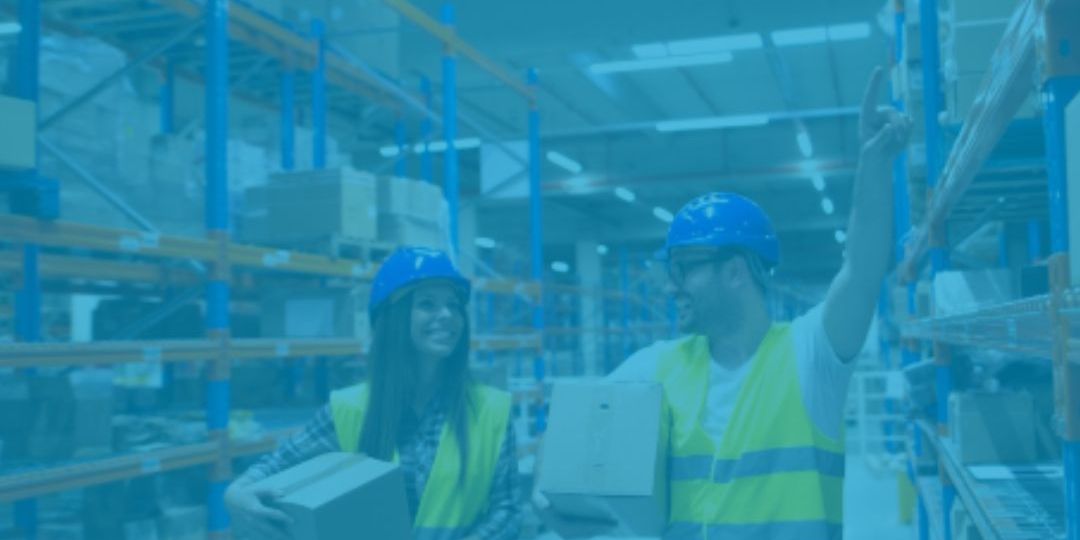 trabalhadores carregando caixa dentro de um galpao logístico iluminado