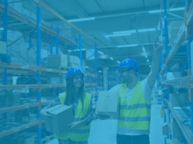 trabalhadores carregando caixa dentro de um galpao logístico iluminado