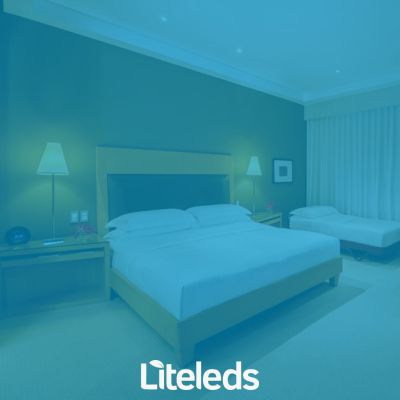 quarto de hotel iluminado por dois abajures com luz amarelada
