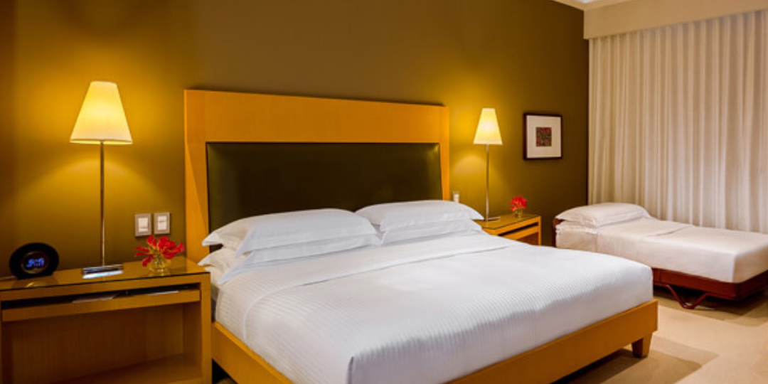 duas luminarias ao lado da cama em um quarto de hotel