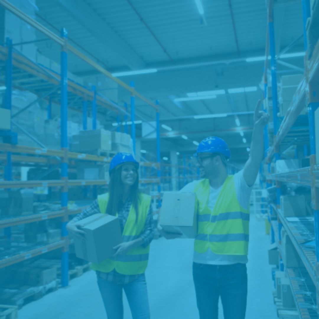 trabalhadores carregando caixa dentro de um galpao logístico iluminado